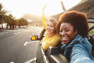 Genç mutlu kadınlar selfie çekerek araba gezintisine çıkıyorlar, gezgin kızlar yeni yerler keşfediyorlar, arkadaşlık ve gençlik sevgilileri tatil yaşam tarzı kavramını keşfediyorlar.