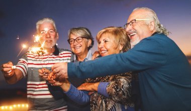 Mutlu son sınıf aile kutlamaları ev partisinde havai fişeklerle - yaşlılar yaşam tarzı ve tatil konseptiyle
