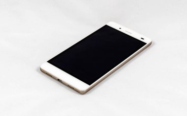 Boş siyah ekranlı modern akıllı telefon yüzeyde duruyor, beyaz arkaplanda izole edilmiş.