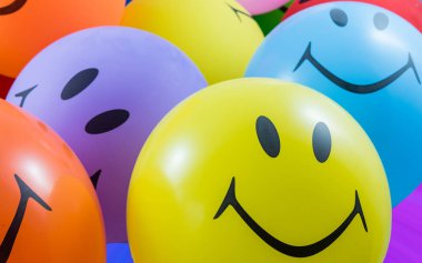 Bir sürü renkli gülen balon. Mutluluk, parti ve mutluluk kavramı