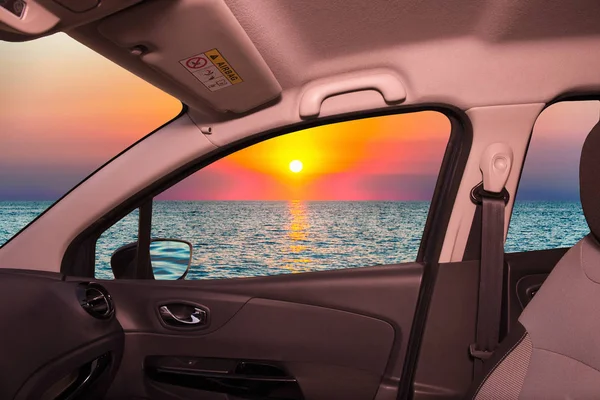 Looking through a car window with view of a scenic sunset on the mediterranean sea