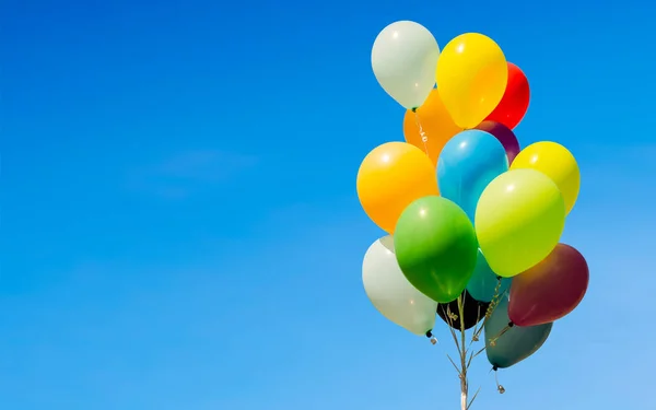 Colorful bunch of helium balloons isolated on background, with copy space