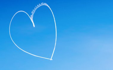 Gökyüzündeki bir uçak tarafından yazılmış romantik bir kalp. Sevgililer Günü için kavram