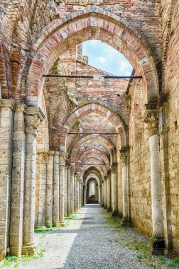CHIUSDINO, İtalya - 22 Haziran 2019 'da İtalya' nın Siena kentindeki Chiusdino kasabasındaki San Galgano Kilisesi 'nin ikonik çatısız manastırının iç manzarası