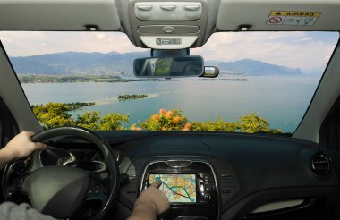 İtalya 'daki Garda Gölü' ne doğru bir GPS navigasyon sisteminin dokunmatik ekranını kullanarak araba sürmek