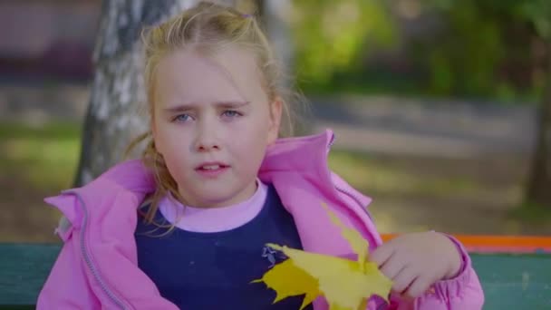 Cute Little Girl With Blonde Hair And Blue Eyes Is Waving On Her