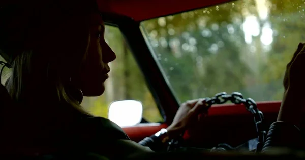 girl silhouette puts hand on steering wheel close view