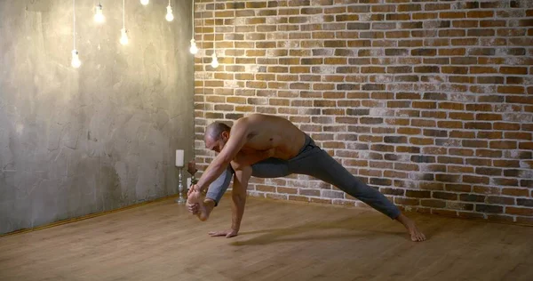 handsome man does yoga asana in cozy studio slow motion