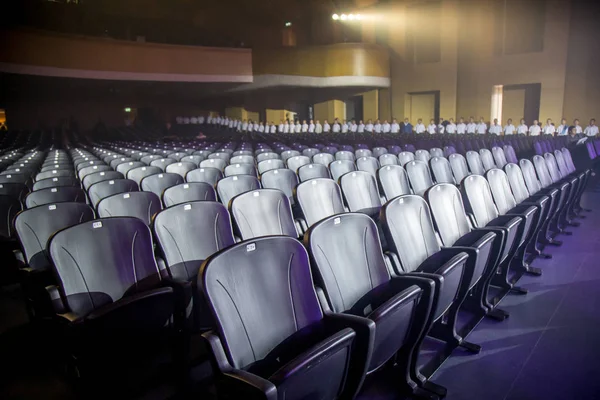 Empty comfortable arm chairs seats with numbers in hall ready for show
