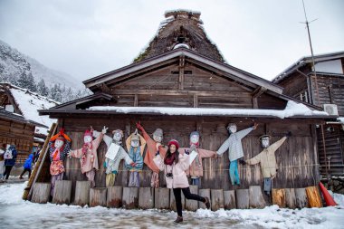 Kız eylemi bir fotoğraf Shirakawa-go village adlı geleneksel ev Gassho tarzı ve bir Unesco Dünya mirası siteleri, Gifu, Japonya dahil olmak üzere kış aylarında