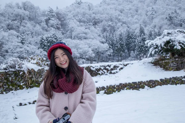 幸せなアジアの女の子は冬など伝統的な合掌造りの家と つのユネスコ世界遺産 岐阜県白川村に雪が降る中に笑顔 — ストック写真