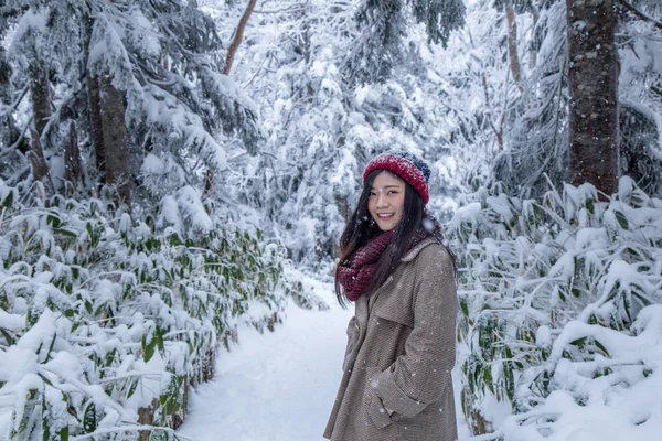 Portrait of woman with red wool hat feeling very happy and cold under snowy weather at Shin-hotaka observation deck, Japan Alps.