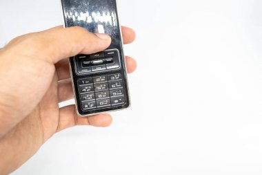Parmak beyaz izole die kesilmiş arka plan ile cep telefonu eski nesil tutan. 1995-2010 yüzyıl boyunca geleneksel cep telefonu.