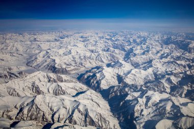 Himalaya dağlarının tepesinden kar ile uçak penceresinden havadan görünümü tüm dağ aralığı kapsamaktadır. Leh Ladakh, Hindistan'da gökyüzü üzerinde tepe tepe üzerinde beyaz yüzey.
