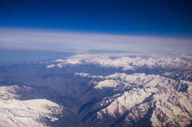 Himalaya kar dağlarının tepesinden havadan bakıldığında, kar lı uçak penceresinden tüm dağ sıralarını kaplar. Leh Ladakh, Hindistan'da gökyüzü üzerinde tepe tepe üzerinde beyaz yüzey.