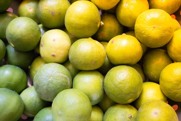 オレンジ色の光効果を持つ金属バスケットにグリーンレモンライムやタイレモン 甘酸っぱい味とのどが渇いた抽象 — ストック写真