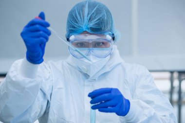 Bilim adamı veya araştırmacı elinde grip, kızamık, koronavirüs, kovid-19 aşı hastalığı taşıyan mavi eldivenlerle insan klinik denemelerine aşı aşısı, ilaç ve ilaç konseptine hazırlanıyor..