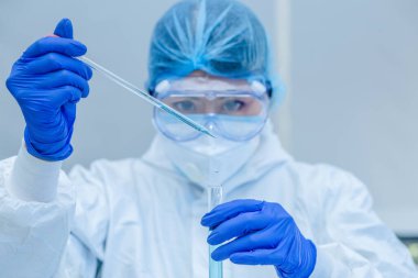 Bilim adamı veya araştırmacı elinde grip, kızamık, koronavirüs, kovid-19 aşı hastalığı taşıyan mavi eldivenlerle insan klinik denemelerine aşı aşısı, ilaç ve ilaç konseptine hazırlanıyor..