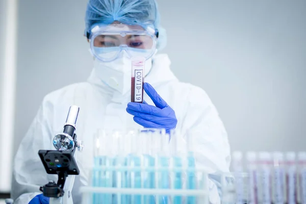 Scientist or researcher hand in blue gloves holding flu, measles, coronavirus, covid-19 vaccine disease preparing for human clinical trials vaccination shot, medicine and drug concept.