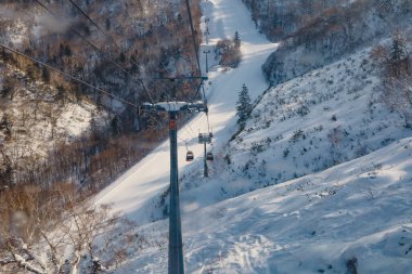Hokkaido, Japonya - Aralık 2019 Kiroro kayak merkezinin alanı. Kayakçılar ve Snowboardcular kış boyunca Japonya 'nın Hokkaido şehrinde tamamen karla kaplı Kiroro Kayak Tatil Köyü' nde Gondola biniyorlar..