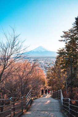 Fuji Dağı ve Chureito Pagoda 'nın güzel manzarası, Fujiyoshida, Japonya. Günbatımında açık mavi gökyüzü ile Fuji sonbahar yapraklarının arka planı.