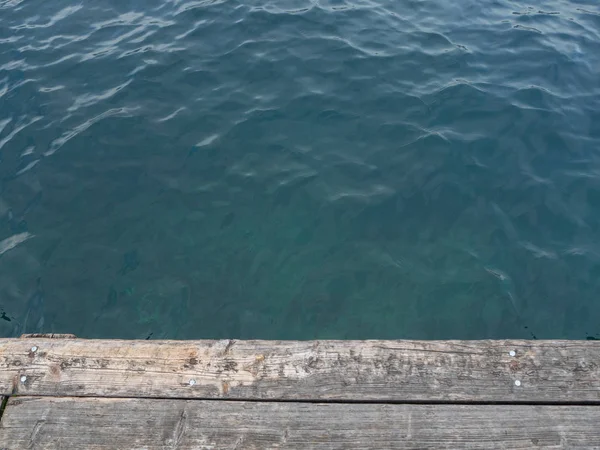 上記の古い木製の桟橋が湖の青い水を表示します ストック写真