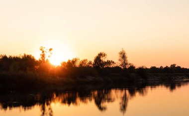 Nehirde gün batımı. Suyun üzerinde gün batımı yansıması.