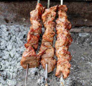 Metal şişte pişen ızgara kebap. Barbeküde pişmiş et. Barbekü taze et dilimleri. Geleneksel doğu yemeği, şiş kebap. Kömür ve alevler üzerine ızgara, piknik, sokak yemekleri
