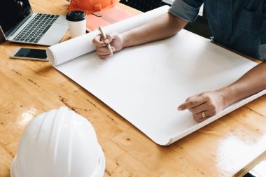 Çalışma planları laptop telefon Emanet dümen ve kahve Kupası, yong mühendis muayene için mimari plan proje, işyerinde Yong mimar adam çizimi bir inşaat projesi, iş kavramı