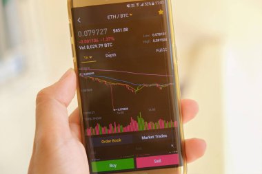 Cryptocurrency Pazar grafik ekranda fiyat sipariş listesi ve el ile smartphone odaklanmak arka plan bulanıklık. Blockchain, Fintech yatırım finansal Internet teknoloji kavramı.