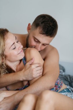 Genç yetişkin çift yatağa sarılma önden görünümü