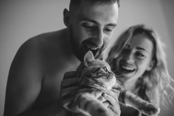 Ellerini, siyah ve beyaz iç kedi ile genç yetişkin çift önden görünümü