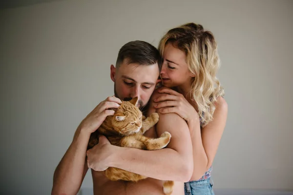 青年夫妇与家养猫的手的前面看法 — 图库照片