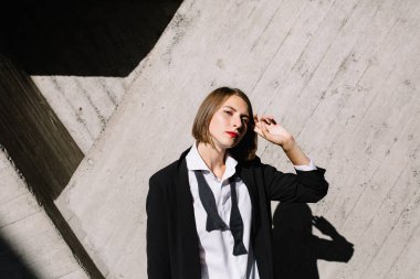 beton duvara poz Klasik takım elbiseli kadın