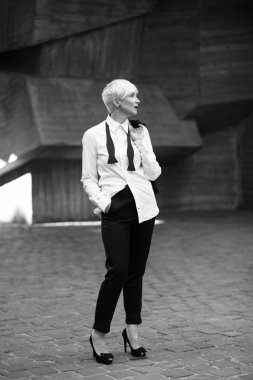 beton duvara poz Klasik takım elbiseli kadın