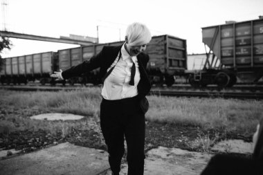 Tren istasyonunda yürüyüş takım elbiseli Genç Bayan 