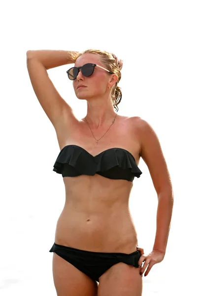 Mujer en gafas de sol y traje de baño negro sobre fondo blanco — Foto de Stock