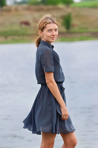Modest woman in simple dress under river