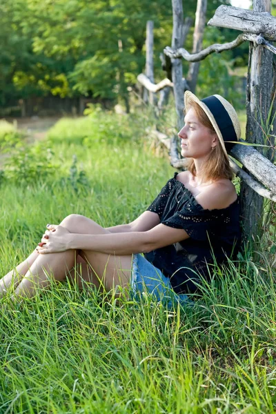 Ung kvinde i halm hat på landet - Stock-foto