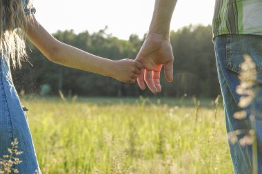 Ebeveyn küçük bir çocuğun elini tutar.