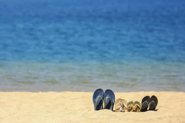 Hausschuhe für die Familie im Sand am Strand — Stockfoto