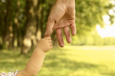 parent holds the hand of a small child clipart