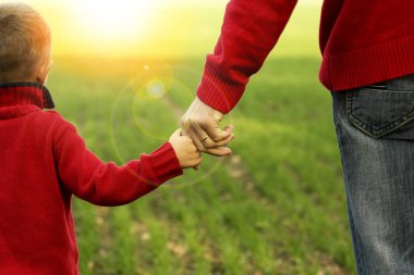 Ebeveyn küçük bir çocuğun elini tutuyor.
