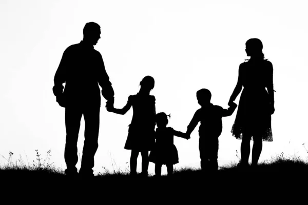 Silhouet van een gelukkig gezin met kinderen — Stockfoto