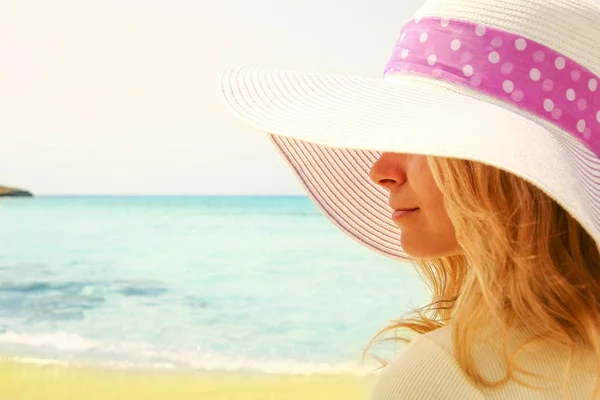 Молодая женщина в шляпе на берегу моря — стоковое фото