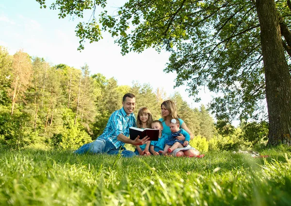 若い家族が自然の中で聖書を読む — ストック写真