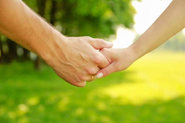 hands Happy parents and child outdoors in the park