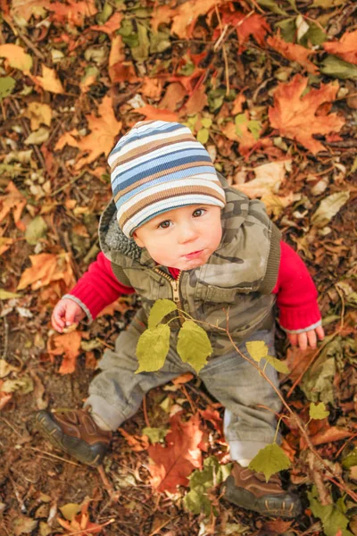 Criança feliz brincando em um parque no outono — Fotografia de Stock