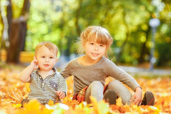 Happy child playing in a park in autumn outdoors — Stock Photo, Image