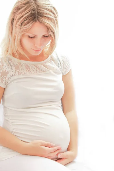 Chica embarazada sobre un fondo blanco —  Fotos de Stock